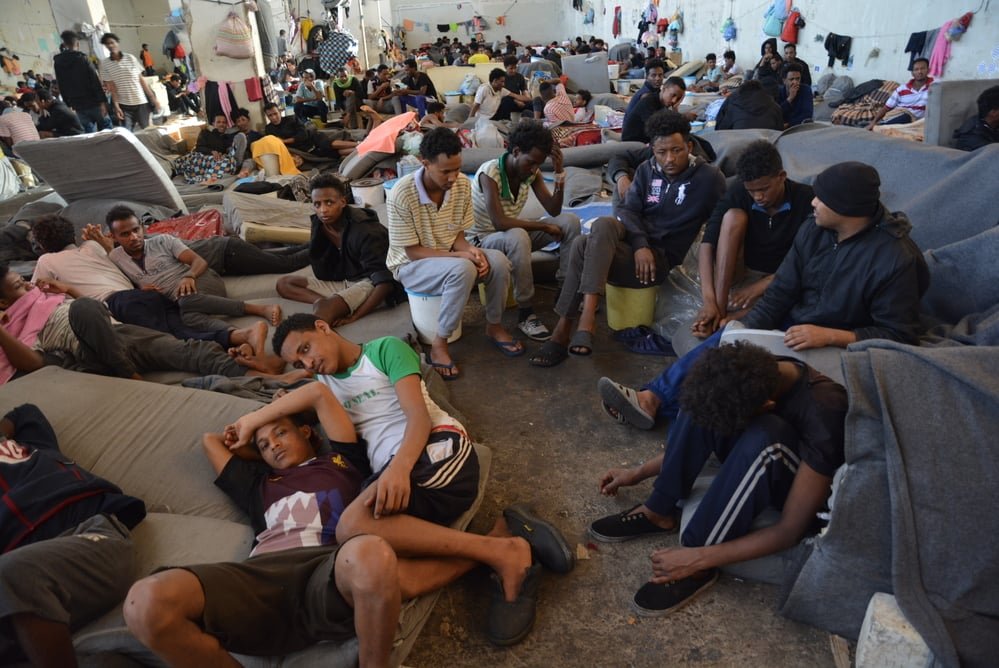 Some of the 700 refugees detained in the main warehouse of Zintan detention centre. In June 2019, the detainees were distributed among other buildings within the compound. Libya, July 2019.