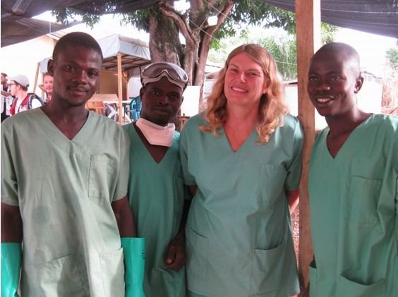 Cokie poses with Water and Sanitation staff outside an Ebola treatment centre in Guinea.