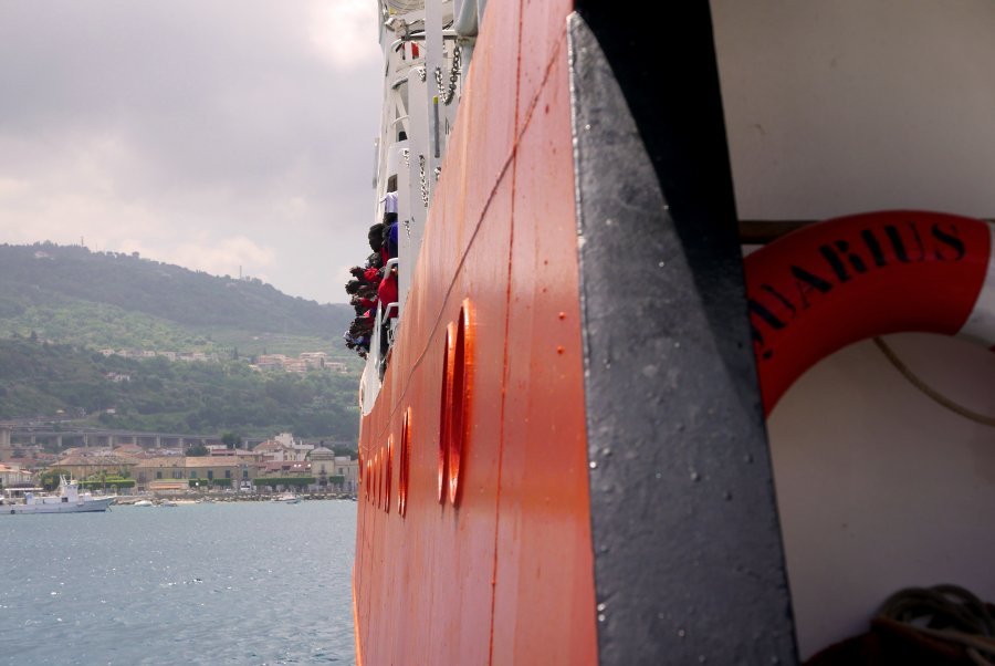People lean out of Aquarius to get a better view of the Italian coast as the ship nears the port of Vibo Valentia.