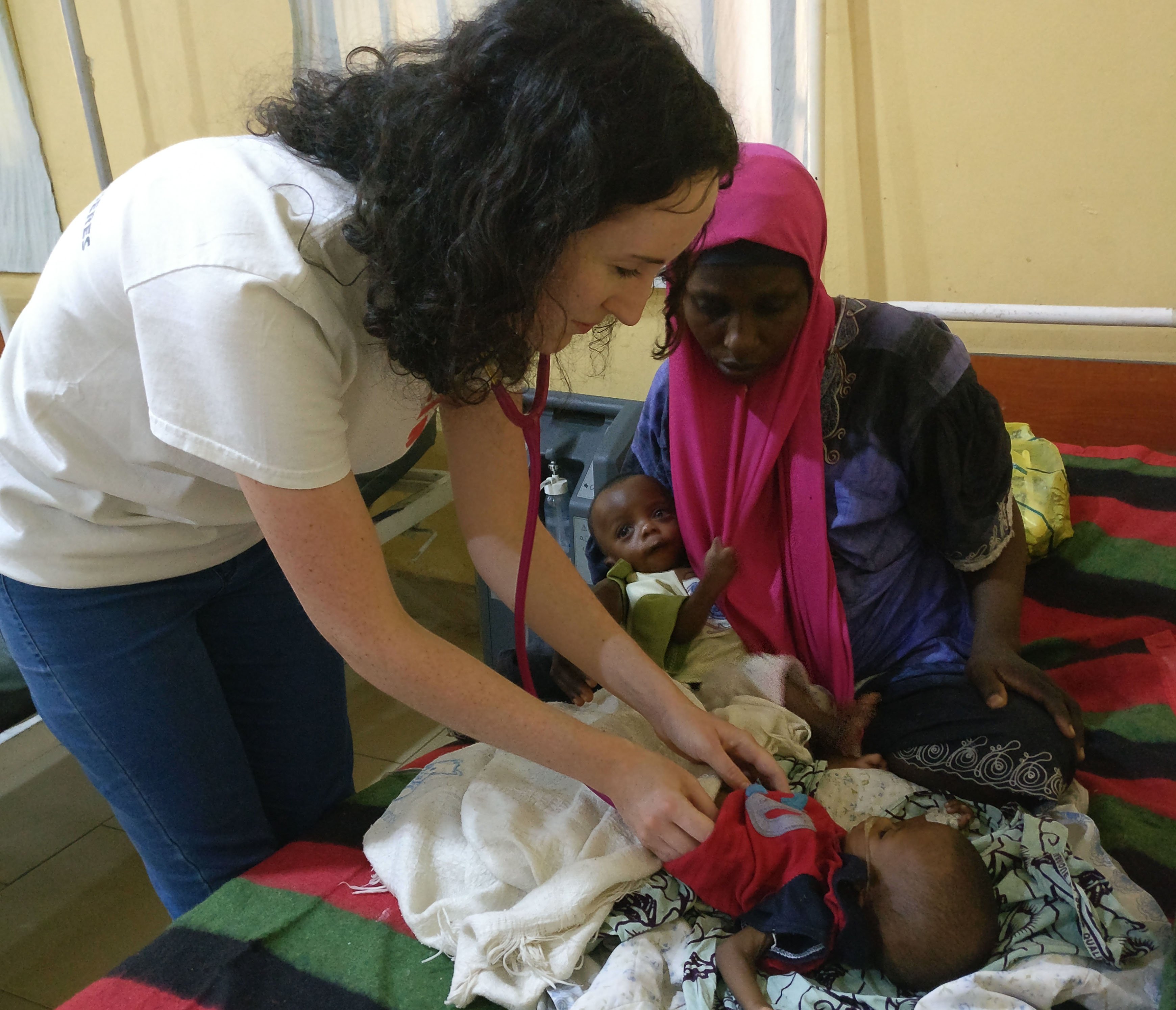 Laura Heavey examining a child suffering complications from malnutrition.