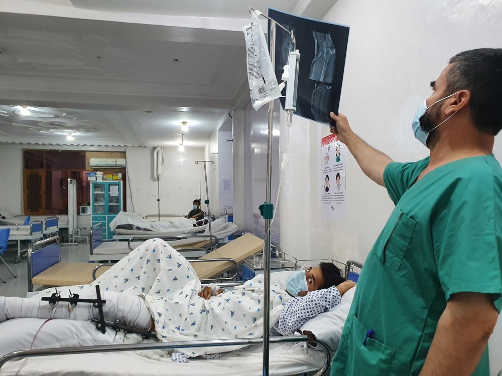 Emergency room of the MSF Kunduz Emergency Trauma Unit, a medic examines the x-ray of a patient who has suffered a complicated fracture of their upper and lower leg due to a bomb blast.