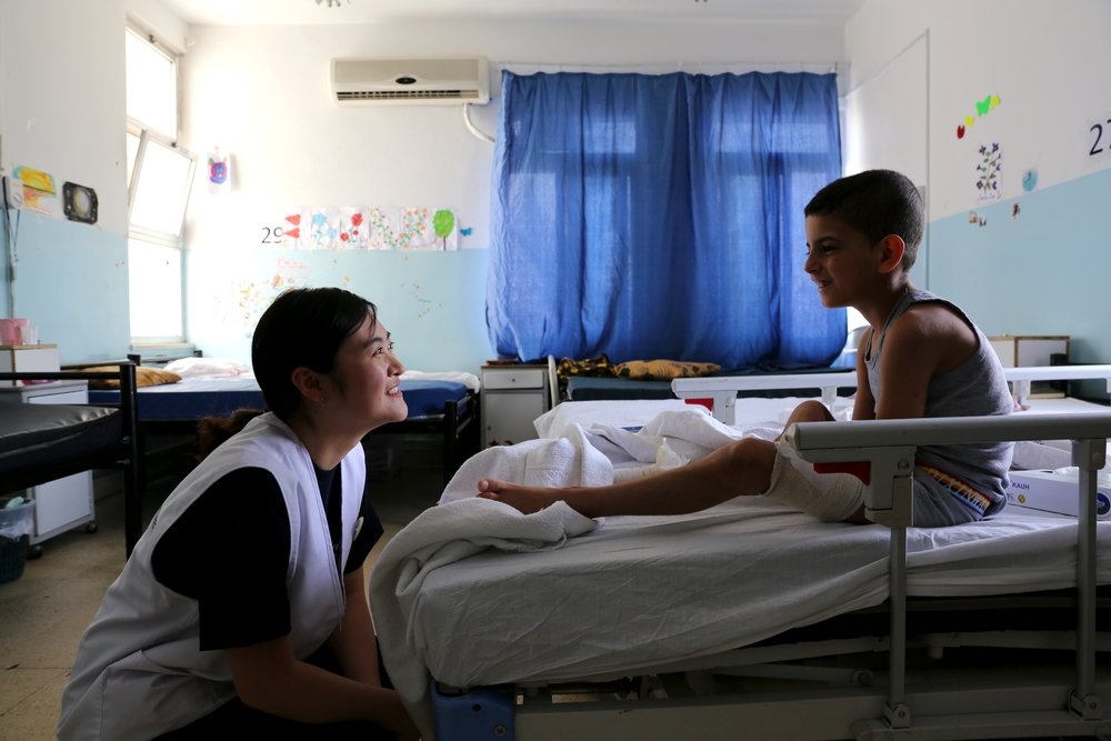 Operating theatre nurse Sunyoung Park spends time with a Syrian boy who is being treated in Ramtha hospital. Operating theatre nurse Sunyoung Park spends time with a Syrian boy who is being treated in Ramtha hospital.