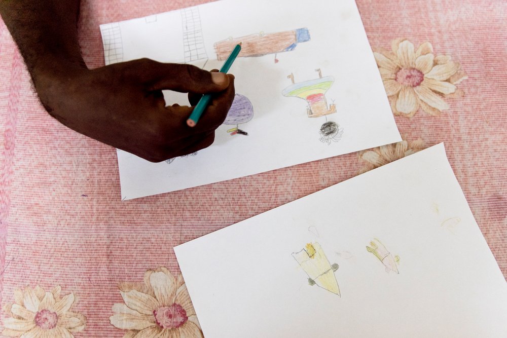 Aimé Césaire Likosso, mental health advisor with the MSF Tongolo project in Bangui, CAR, points out details in drawings made by child sexual assault survivors on 30th November 2020.