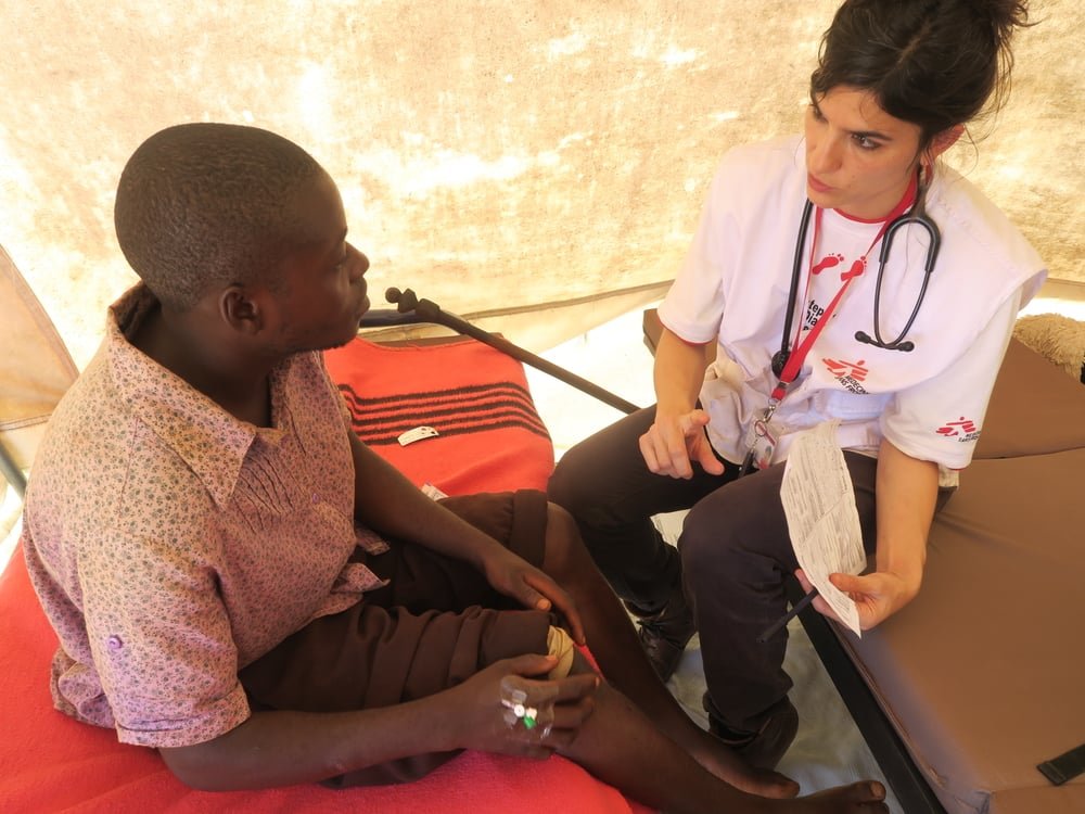 An MSF doctor attends to a man in Chimanimani who sustained injuries after being swept away by heavy rains caused by Cyclone Idai. Zimbabwe, March 2019.