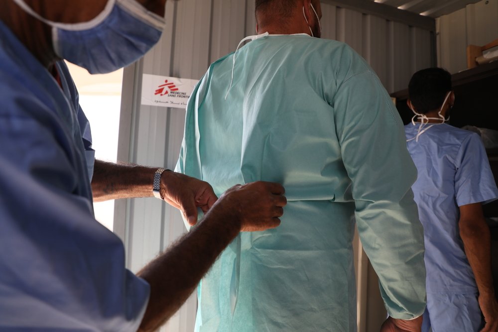 MSF team is team members putting on protective gowns