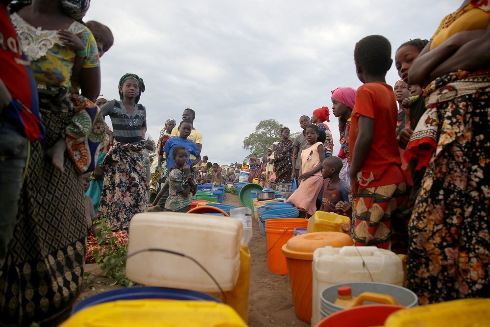 Dozens of women and girls queue for water after MSF trucked 8,000 litres of water to an open space on the outskirts of Mueda. (December, 2021).