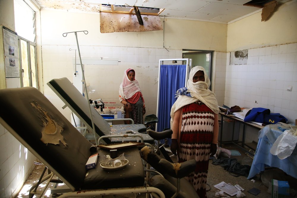 Fatimah* (front) and y Mariam*(back) survey the damage to the delivery room of the health centre in Sebeya town, in the northern Ethiopian region of Tigray. Both women are in an advanced state of pregnancy. *pseudonyms