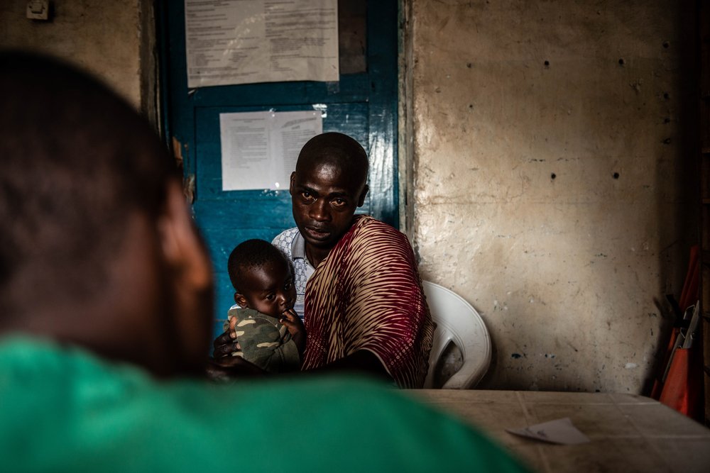 JULES MUNGUIKO, 35 years old, brings his son for health screening at the Afia Sake&#039;s health center.