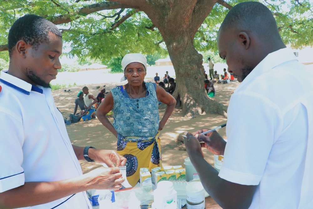 Ministry of Health workers are seen attending to an elderly woman at a mobile clinic at Kampata in Nsanje district. (February, 2022).
