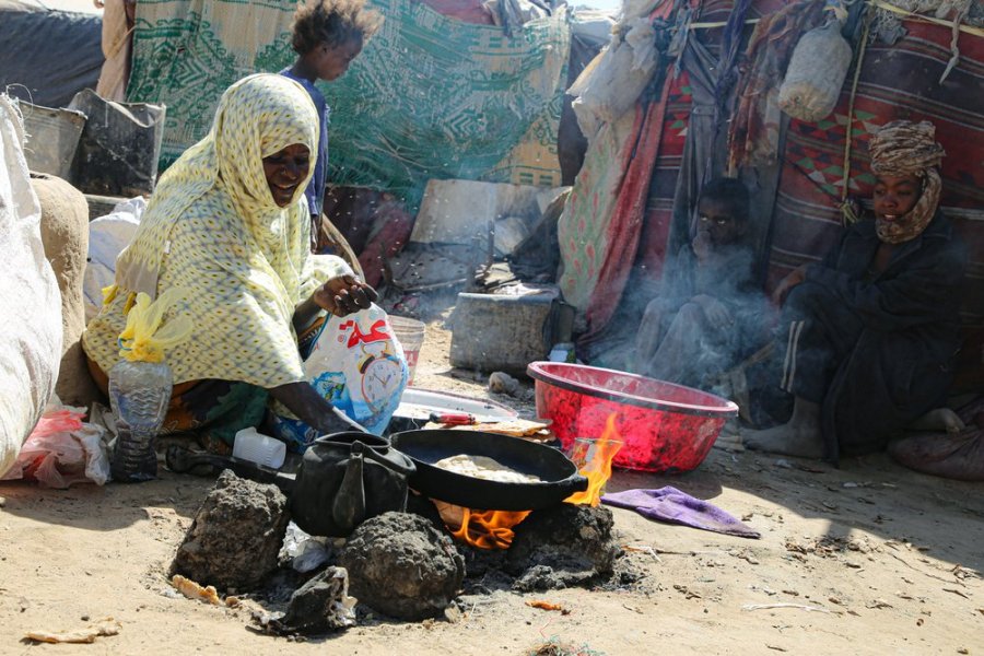 Life in Hareeb Junction camp in Marib. A woman making her lunch of bread and tea. To fuel the fire she uses trash.