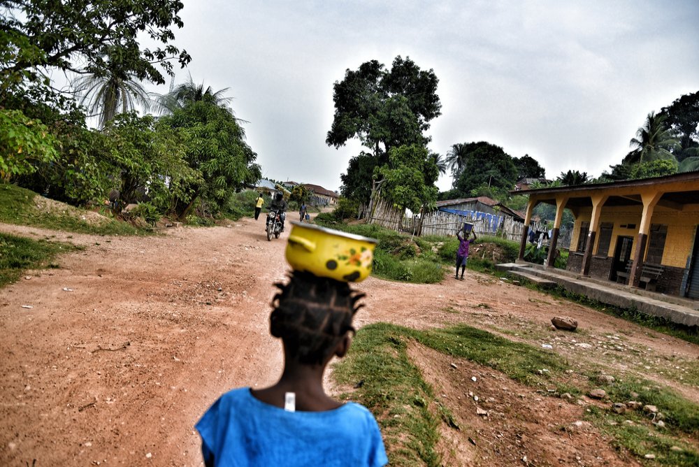 Part of the daily life in Kenema district. A young girl carries food as she walks through one of the villages in Gorama Mende chiefdom in eastern Kenema district.