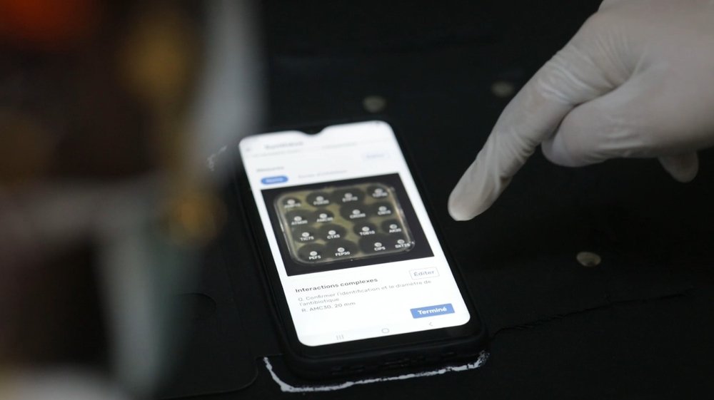 Dr. Nada Malou, program manager and clinical lead at the MSF Foundation, points to a smartphone screen on which the Antibiogo application is open and displays an antibiogram. (December, 2021).