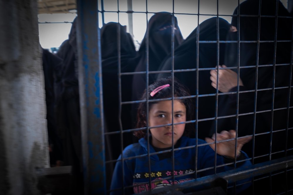 A young girl looking through a closed fence in Al-Hol Camp, Eastern Al- Hasakah Governorate, Northeastern Syria.