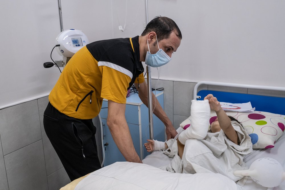 Mohammed Aboud comforts his four-year-old daughter Hala as she recovers from reconstructive surgery on her foot. 