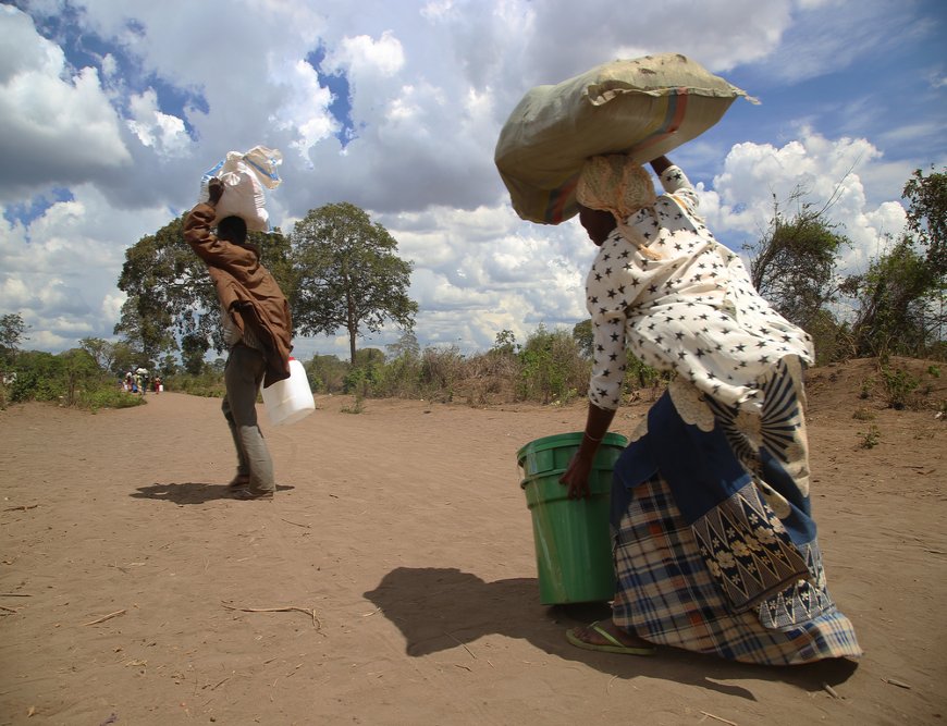 A man and woman carry a set of relief items distributed by an MSF. (December, 2021).