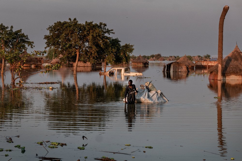 A man drags a tarpaulin raft through the flood in Rubkona, Unity State. (December, 2021).
