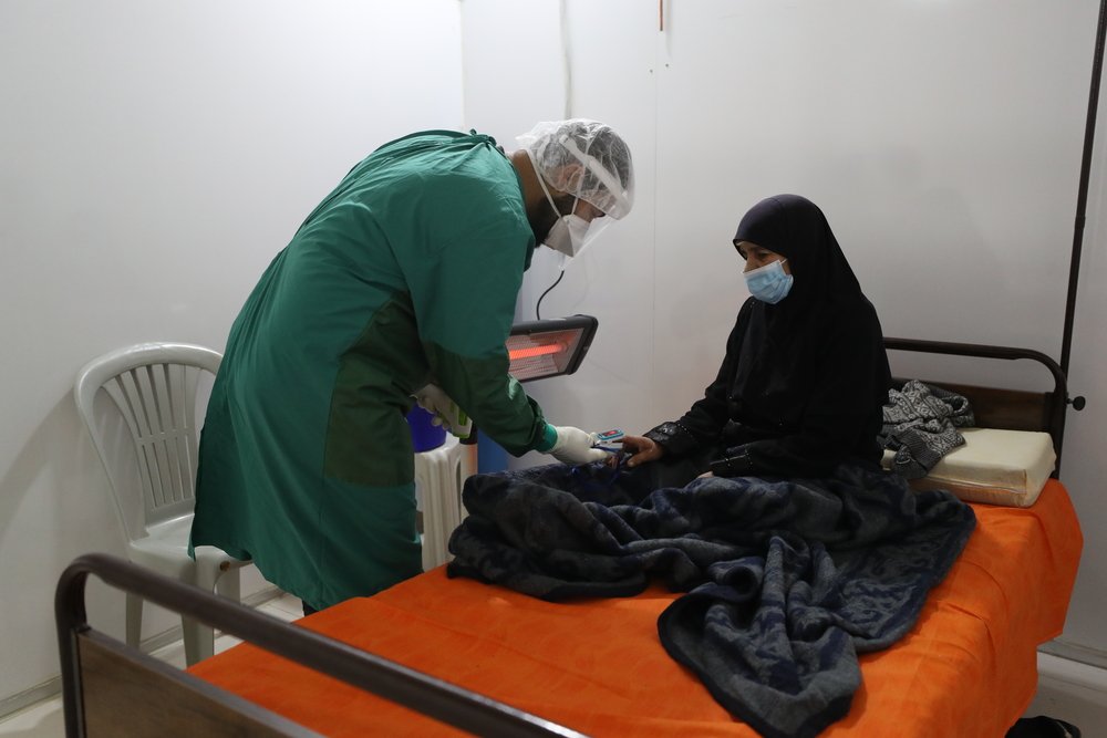 MSF nurse checking a patient’s oxygen level inside the ward for patients with confirmed COVID-19. Inside MSF’s isolation and treatment centre in northwest Syria. December 2020.