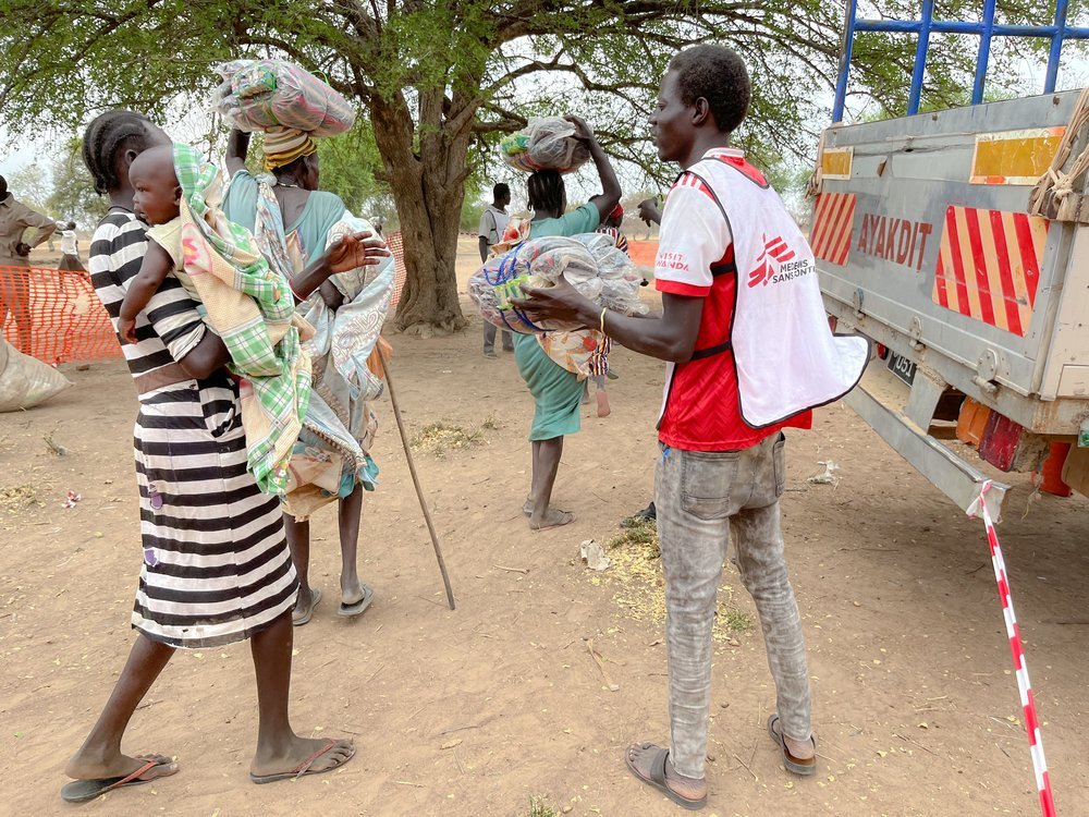 Members of the MSF logistics team distribute blankets and jerry cans in Nyin Deng Ayuel displacement camp in Twic County. (April, 2022).