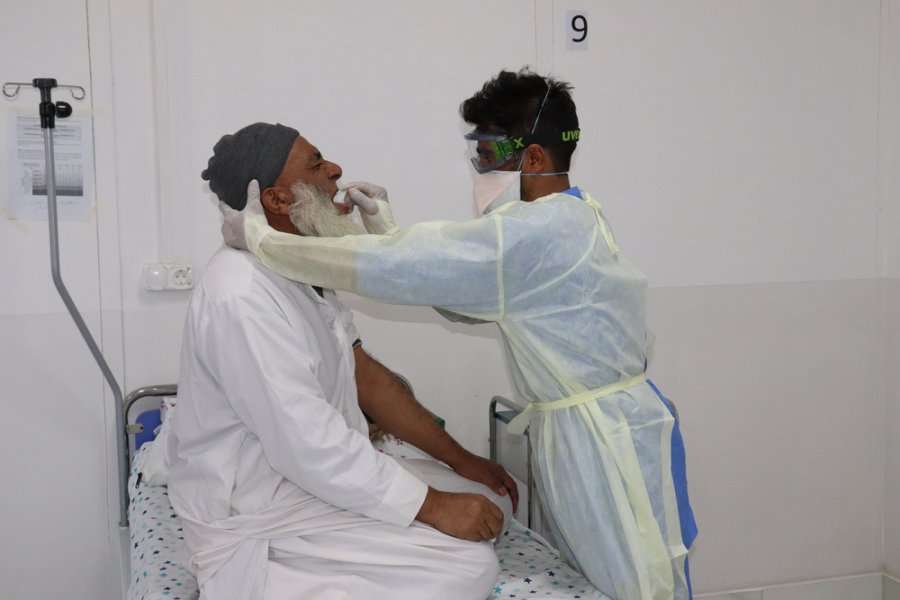 MSF nurse Norrulah Nasrat collects a sample from Mohammadin, a COVID-19 suspected patient, in MSF’s COVID-19 Treatment Centre in Herat, in Afghanistan.