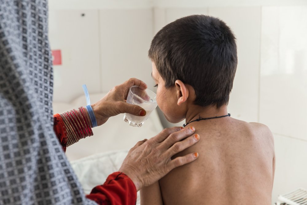Saed Bibi is giving a glass of milk to her son Saddiqulah, 10, in the paediatric department of the MSF supported Boost hospital in Lashkar Gah, Helmand province. (February, 2022).