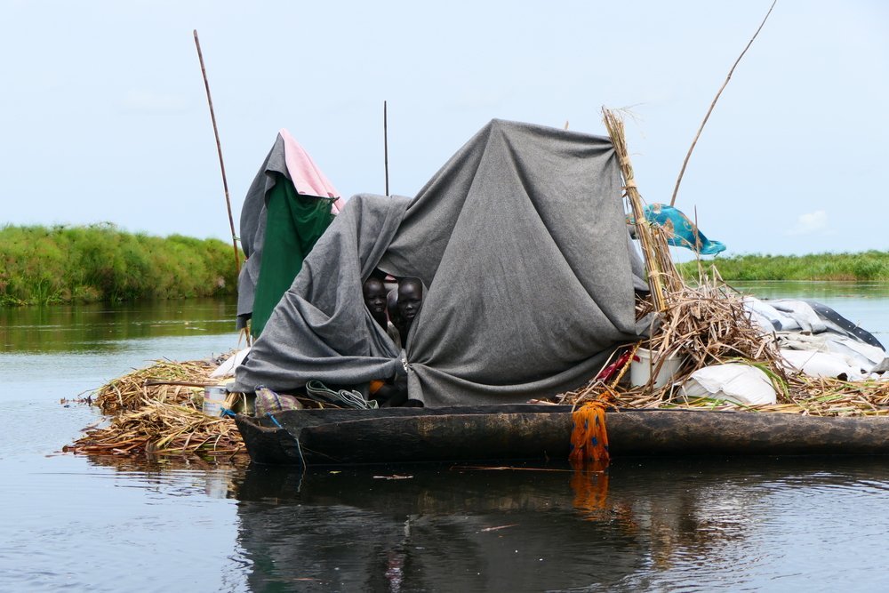 Displaced family used blankets and plastic sheeting to build shelter on a kind of grass raft to navigate in the river connecting Ayod and Fangak Counties.