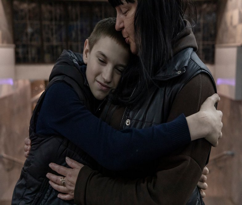 Ludmilla, 40-years-old kisses the head of her son Vladislav, 11-years-old, in Kharkiv, Ukraine. (April, 2022).