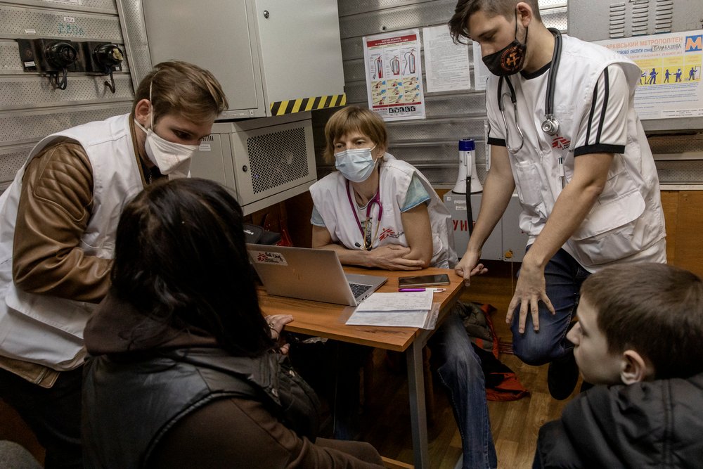 Ludmilla, 40-years-old and her son Vladislav, 11-years-old, are being checked by Kirill, Kelly and Grisha from MSF in a metro station in Kharkiv, Ukraine. (April, 2022).