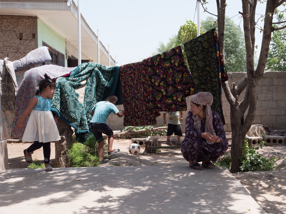 Bibisoleha and Zainidin are playing in front of the house in west Tajikistan where they live with their mother and grandparents. (July, 2021).