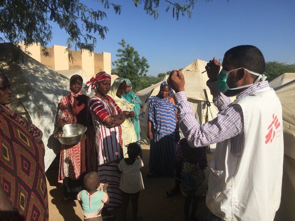 Mohamed, the MSF health promotion supervisor, explains to the displaced people living on the site in Sokolo how to protect against COVID-19.