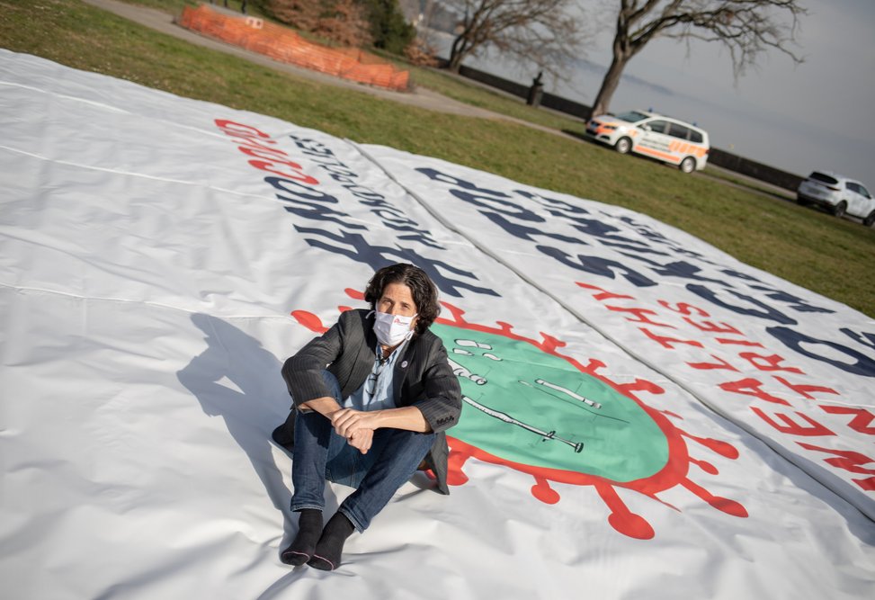 Stephen Cornish, General Director  of MSF operational center of Geneva, sitting on the banner deployed by MSF in front of the World Trade Organization in Geneva calling on certain governments to stop blocking the landmark waiver proposal. (March 2021).