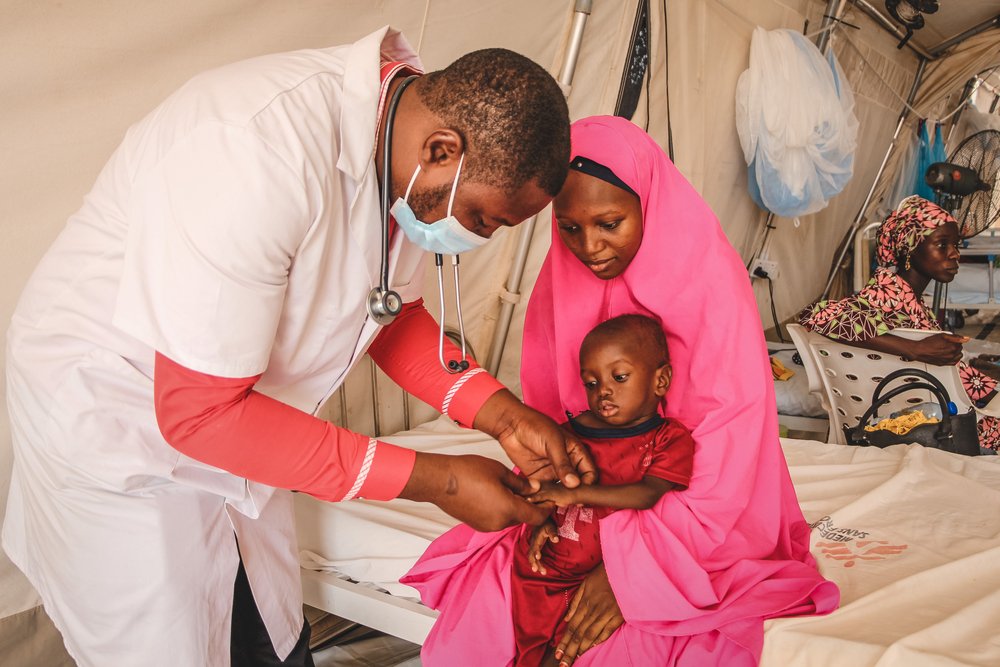 An MSF doctor Ibrahim Fori Bwala examines Ja’afar Ahmed, a severely malnourished child admitted to the inpatient therapeutic feeding centre (ITFC) at Nilefa Kiji nutrition hospital run by MSF in Maiduguri, Borno State in Nigeria. (June, 2022).