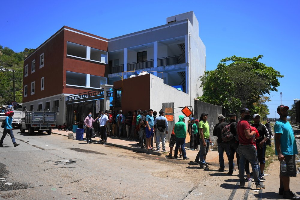 Dozens of migrants line up outside the shelter of the Casa del Migrante Diocesis of Coatzacoalcos to receive food. Due to the COVID-19 pandemic, the shelter authorities are not allowing access to migrants. 