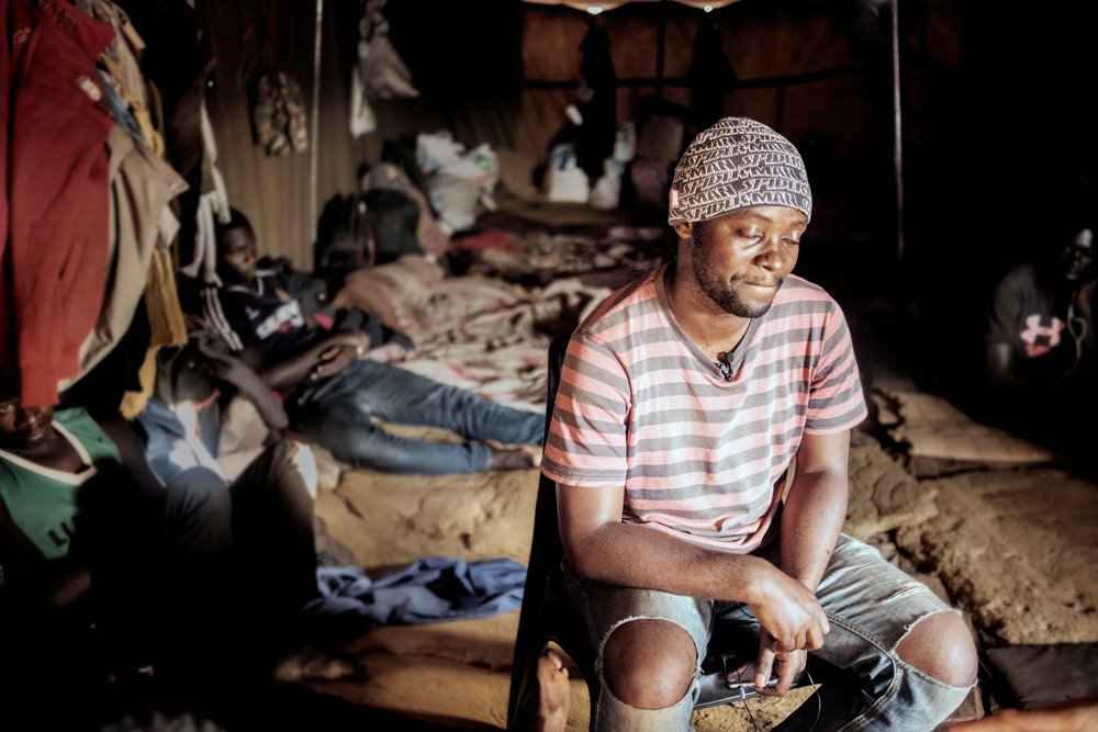 A migrant from the DRC sits in a tent at a temporary shelter for migrants travelling into South Africa. © Luca Sola 2019