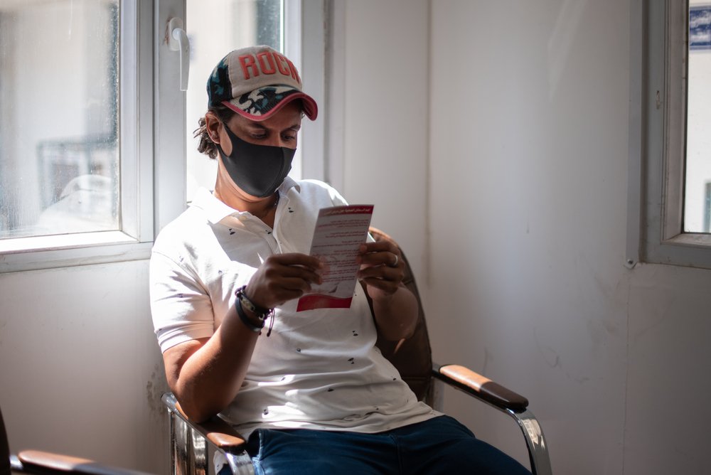 Rawabi reads a leaflet about tuberculosis in the waiting room set up especially for multidrug-resistant tuberculosis patients, in the MSF-run dedicated clinic, separated from the rest of the centre.