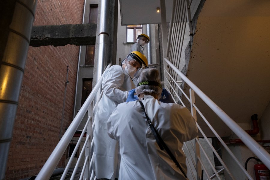 MSF staff talk with a patient in a medical facility MSF set-up in Brussels, Belgium. People who live in the streets can come here for medical care if they have COVID-19, or if they need to isolate because they’re likely to be infected.