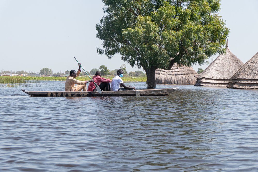 Men in a canoe navigate the flood waters in Bentiu, Unity state, where people’s homes and livelihoods (crops and cattle), as well as health facilities, schools, and markets, are completely submerged by floodwaters.