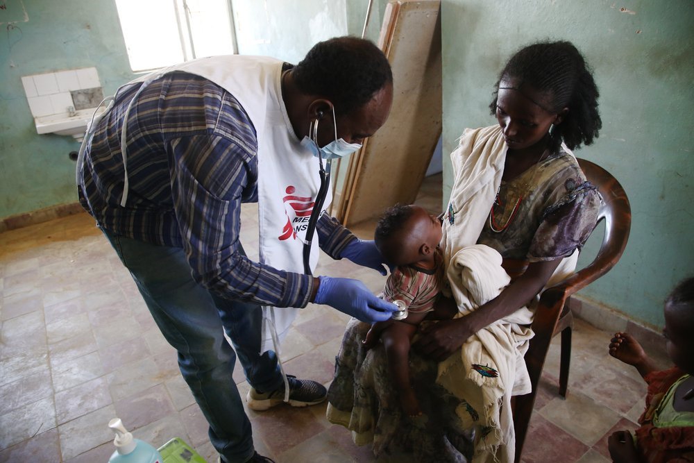 MSF medic  examines a child during a mobile clinic in the village of Adiftaw, in the northern Ethiopian region of Tigray.