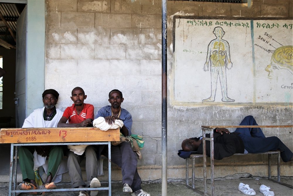 A group of displaced men sit at a bench at Kundeya school in Axum, central Tigray.