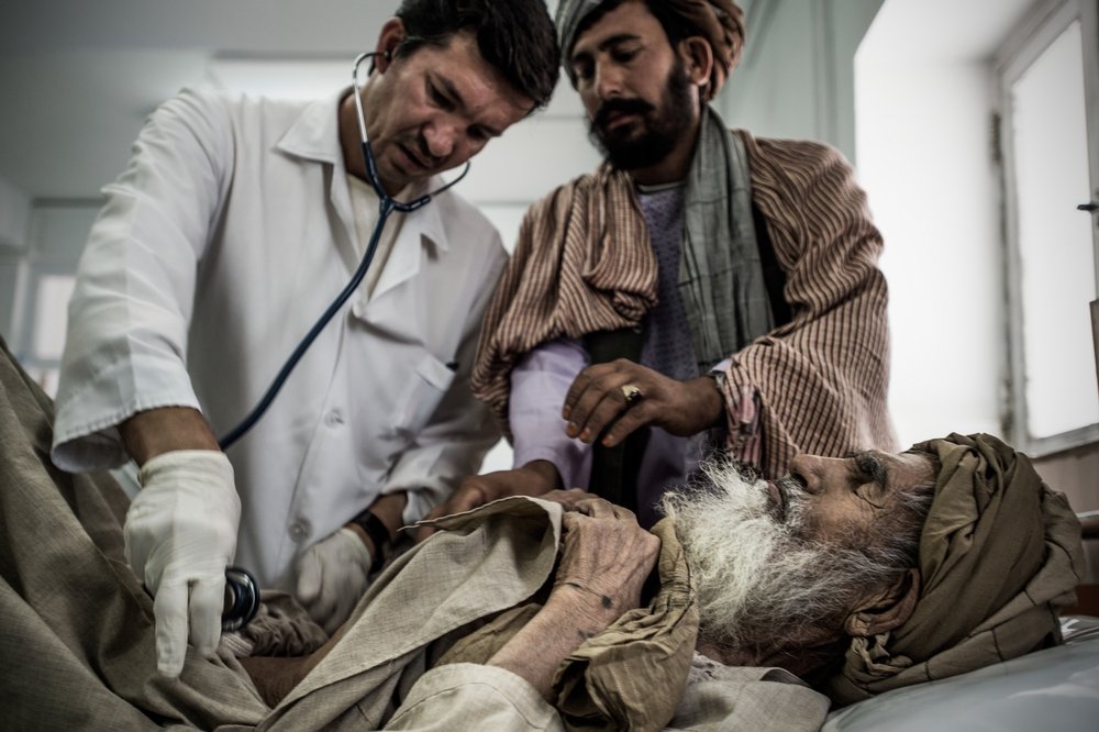 Dr Farid (L) checks a patient in the emergency room of Boost hospital, Lashkar Gah, Helmand, Afghanistan