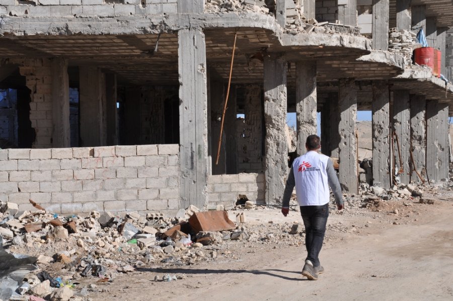 An MSF staff member walks by a building destroyed in the conflict, Kobane, January 23, 2017.