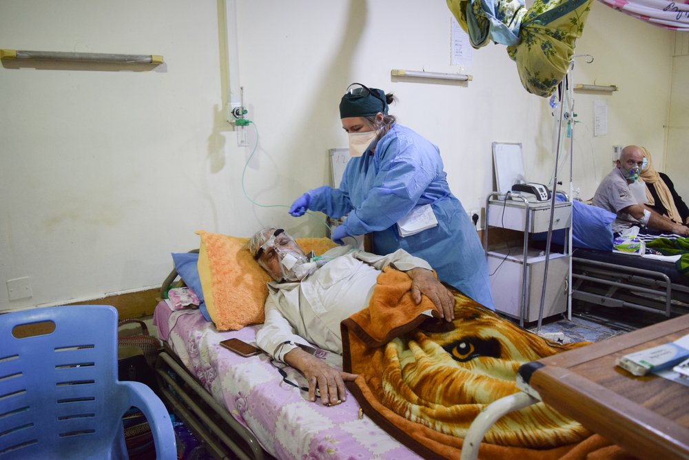 An MSF nurse adjusts the oxygen supply of a patient with COVID-19 at the COVID-19 treatment centre in Al-Kindy hospital, Baghdad. Iraq, September 2020.