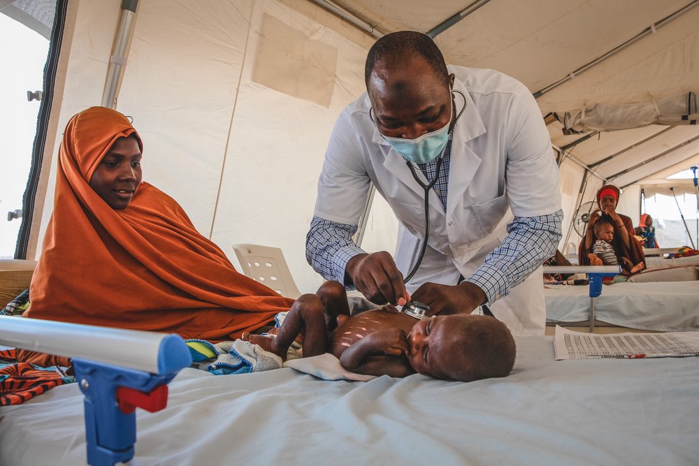 Dr Bukar M. Galtimar examining a severely malnourished child admitted to the inpatient therapeutic feeding centre (ITFC) at Nilefa Kiji nutrition hospital run by MSF in Maiduguri, Borno State in Nigeria. (June, 2022),
