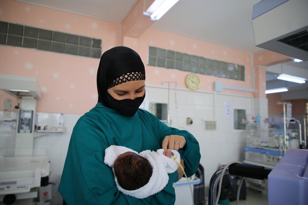 MSF nursing activity manager Réne Stone holds a newborn child admitted to the special care baby unit supported by MSF at Al-Jamhouri hospital in Taiz City, Yemen.