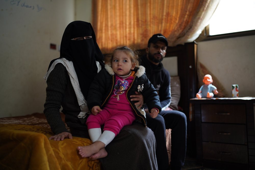 A two-year-old Sham sits with her parents in a rented room in Khan Younis refugee camp in the south of Gaza. (December, 2021).