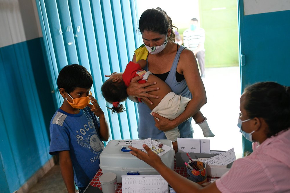Noble Garcia takes his grandson Angel, who has symptoms of malaria, to the ambulatory clinic in San Vicente, in a rural area of Sucre state in northeastern Venezuela, for a diagnostic test for the disease. (May 2021).