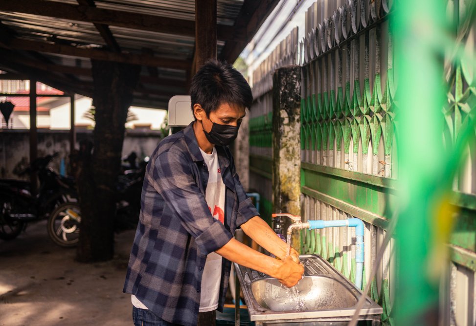 Brang Seng, 30, who was diagnosed with HIV in April 2021, washes his hands as a COVID-19 prevention measure before entering MSF’s Myitkyina clinic in Kachin state.
