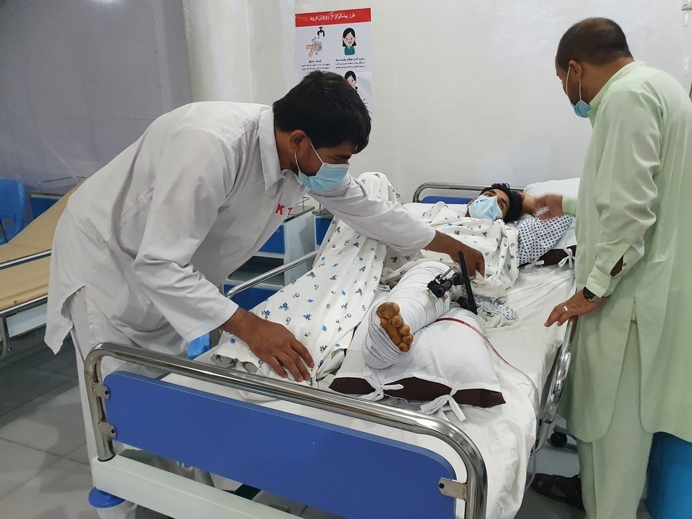 Emergency room of the MSF Kunduz Emergency Trauma Unit, a medic treats a patient who has suffered a complicated fracture of their upper and lower leg due to a bomb blast.
