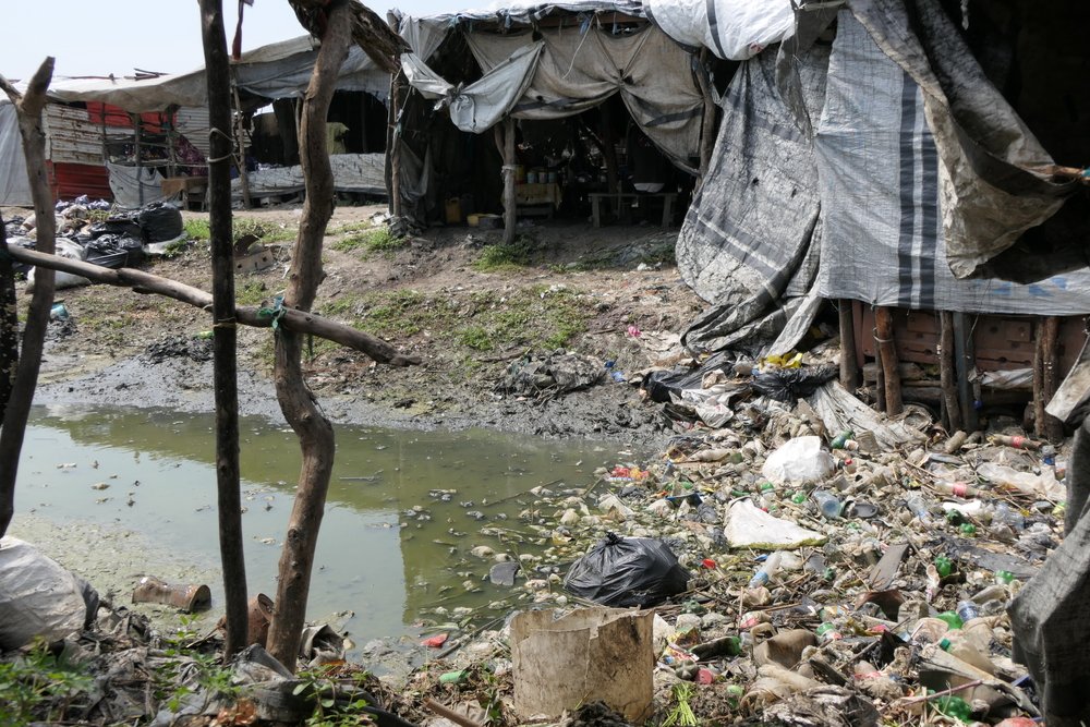 A garbage area in the main street market of Bentiu IDP camp. People buy all sorts of items in the tents surrounding the garbage, including food.