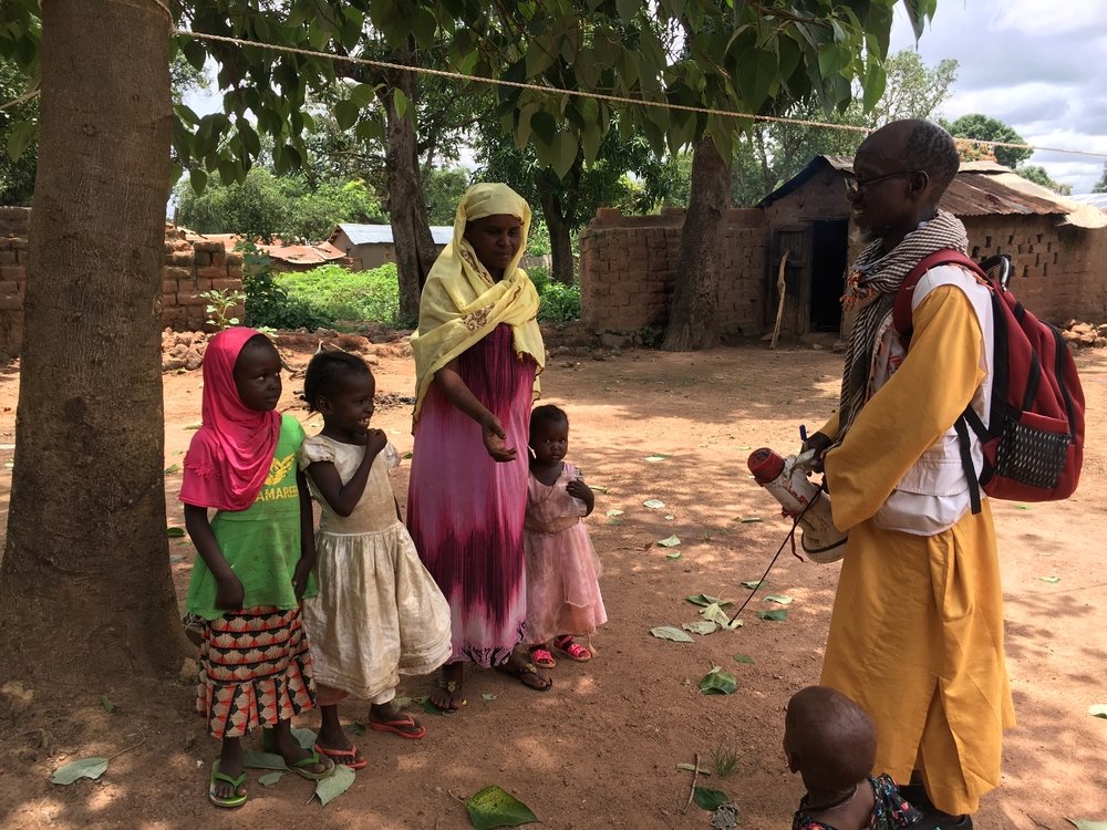 An MSF team member informs the community about the upcoming MDA campaign.
