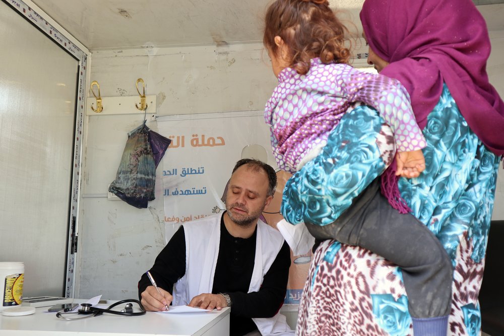 MSF mobile clinic doctor Mohamed Yaqub conducts a consultation with a woman and her child recently displaced by the conflict in northwest Syria, May 2019.